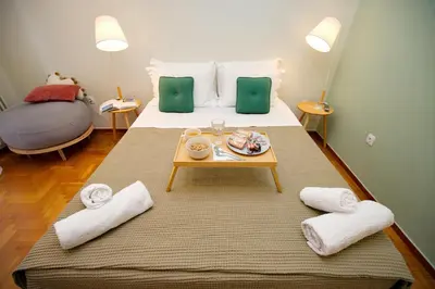 a bedroom with a bed with a tray of food on it at Olga's Lovely Elia Apartment - Kaisariani in Athens