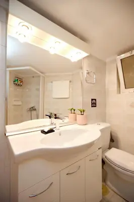 a bathroom with a sink and a toilet and a mirror at Olga's Lovely Elia Apartment - Kaisariani in Athens