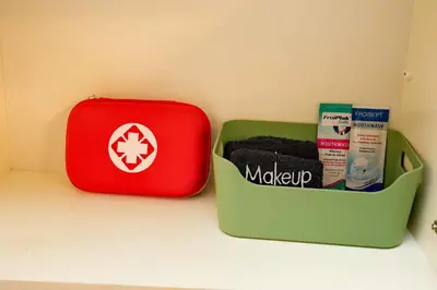 a red and green container sitting next to a suitcase at Olga's Lovely Elia Apartment - Kaisariani in Athens