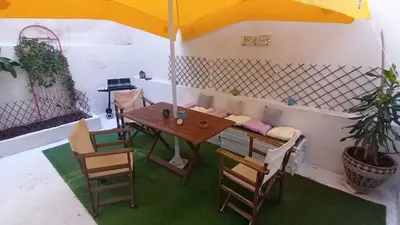 a table and chairs with an umbrella on a patio at Ισόγειο διαμέρισμα με υπαίθριο χώρο in Athens