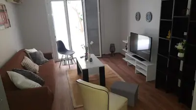 a living room with a couch and a tv at Ισόγειο διαμέρισμα με υπαίθριο χώρο in Athens