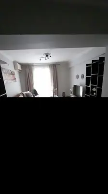 a living room with a window and a couch at Ισόγειο διαμέρισμα με υπαίθριο χώρο in Athens