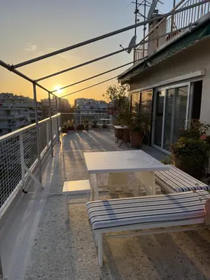 a patio with a table and benches on a balcony at Beach rooftop Athens Riviera in Athens