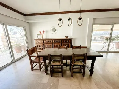 a dining room with a wooden table and chairs at Beach rooftop Athens Riviera in Athens