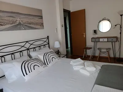 a bedroom with a white bed with two pillows at Cosy apartment on Dragon street in Athens