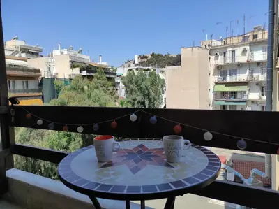 a table with two coffee cups on a balcony at Cosy apartment on Dragon street in Athens