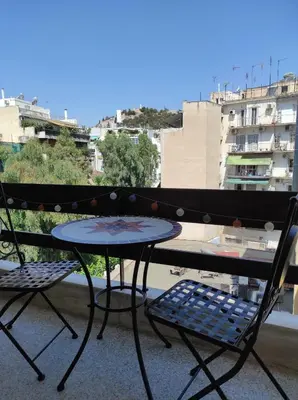 a table and two chairs on a balcony at Cosy apartment on Dragon street in Athens