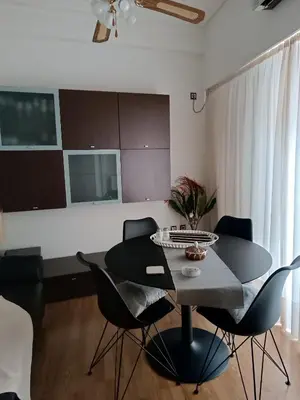 a dining table and chairs in a living room at Cosy apartment on Dragon street in Athens