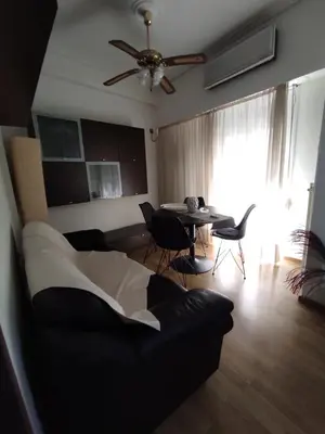 a living room with a couch and a table with chairs at Cosy apartment on Dragon street in Athens