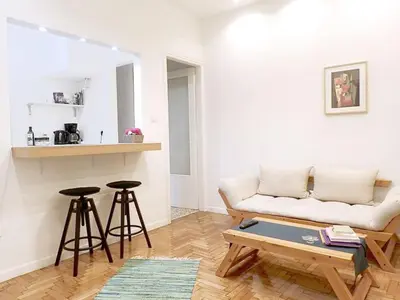 a living room with a couch and two bar stools at Athens Pangrati cute apt, 15 mins from metro in Athens