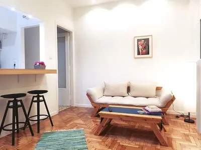 a living room with a couch and two bar stools at Athens Pangrati cute apt, 15 mins from metro in Athens