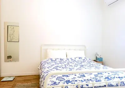 a bedroom with a bed with a blue and white comforter at Athens Pangrati cute apt, 15 mins from metro in Athens