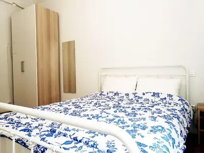 a bedroom with a bed with a blue and white comforter at Athens Pangrati cute apt, 15 mins from metro in Athens