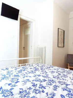 a bedroom with a bed with a blue and white blanket at Athens Pangrati cute apt, 15 mins from metro in Athens