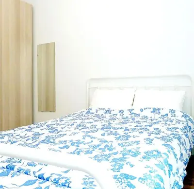 a bedroom with a bed with a blue and white comforter at Athens Pangrati cute apt, 15 mins from metro in Athens