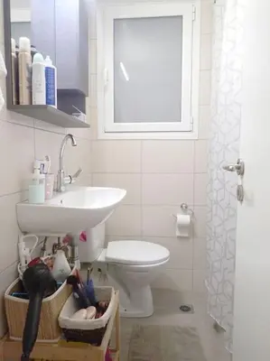 a bathroom with a sink and a toilet and a window at Athens Pangrati cute apt, 15 mins from metro in Athens