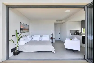 a bedroom with a large bed and white furniture at Vouliagmeni Panoramic 200m2 Rooftop & 25m2 Loft in Athens