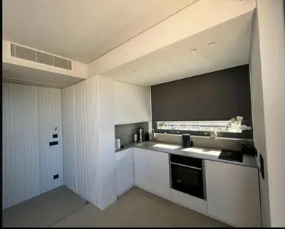 a kitchen with white cabinets and a stove top oven at Vouliagmeni Panoramic 200m2 Rooftop & 25m2 Loft in Athens
