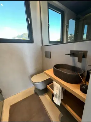 a bathroom with a sink and a toilet and a mirror at Vouliagmeni Panoramic 200m2 Rooftop & 25m2 Loft in Athens