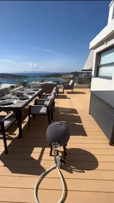 a deck with benches and tables on a building at Vouliagmeni Panoramic 200m2 Rooftop & 25m2 Loft in Athens