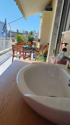 a white sink on a wooden table on a balcony at cozy διαμέρισμα με υπέροχη θέα ! in Athens