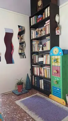 a room with a book shelf filled with books at cozy διαμέρισμα με υπέροχη θέα ! in Athens
