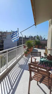 a balcony with a bench and an american flag at cozy διαμέρισμα με υπέροχη θέα ! in Athens