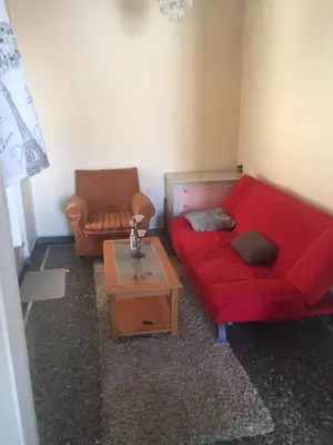 a living room with a red couch and a coffee table at Simple & Spacious - Shared Accomodation in Athens