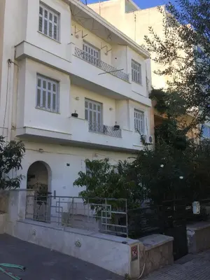 a white building with balconies on the side of it at Simple & Spacious - Shared Accomodation in Athens