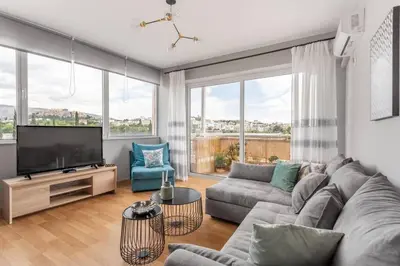 a living room with a couch and a flat screen tv at Charming Acropolis view modern design House 2BD in Athens