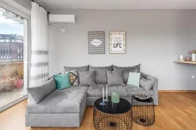 a living room with a gray couch and a table at Charming Acropolis view modern design House 2BD in Athens