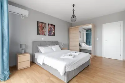 a bedroom with a large white bed and a mirror at Charming Acropolis view modern design House 2BD in Athens