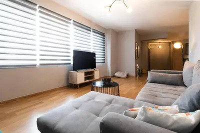 a living room with a couch and a flat screen tv at Stunning Acropolis view modern design house 2BD in Athens