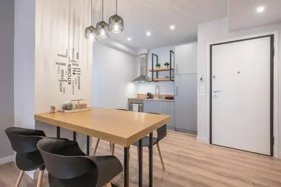 a kitchen with a wooden table and black chairs at Urban & Spacious Apartment in Athens