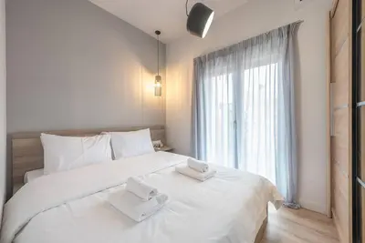 a bedroom with a large white bed with two towels on it at Urban & Spacious Apartment in Athens