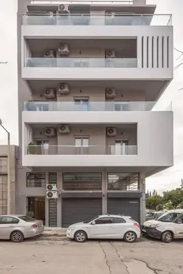 two cars parked in front of a tall building at Urban & Spacious Apartment in Athens