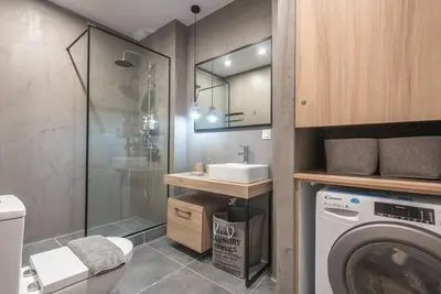 a bathroom with a washing machine and a sink at Urban & Spacious Apartment in Athens