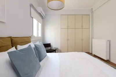 a bedroom with a large white bed with blue pillows at Faliro Serenity 2BD Apartment by UPSTREET in Athens