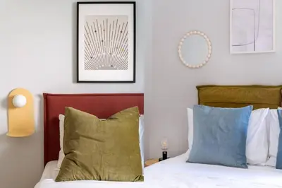 a bedroom with a bed with green and blue pillows at Faliro Serenity 2BD Apartment by UPSTREET in Athens