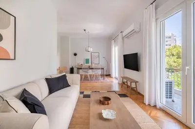a living room with a white couch and a table at Faliro Serenity 2BD Apartment by UPSTREET in Athens