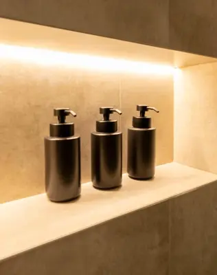 two bottles ofodorizers sitting on a shelf in a bathroom at Derouse Eva Suite Jacuzzi & Sauna in Athens