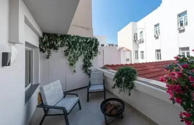 two chairs and a dog sitting on a balcony at Derouse Eva Suite Jacuzzi & Sauna in Athens