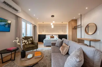 a living room with a couch and a bed at Derouse Eva Suite Jacuzzi & Sauna in Athens