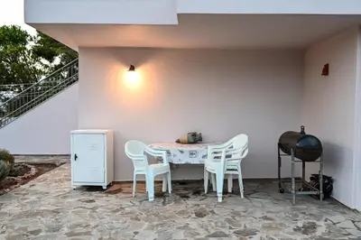 a patio with a table and chairs and a staircase at Marina's dream house in Sounio
