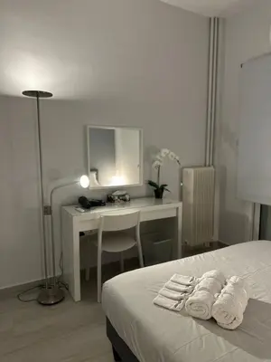 a bedroom with a desk and a bed with towels at Koukaki Urban Living Apartment in Athens