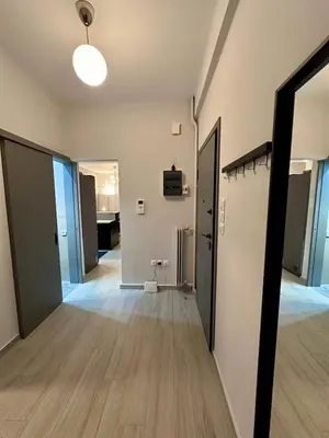 an empty room with a hallway with doors and wood floors at Koukaki Urban Living Apartment in Athens