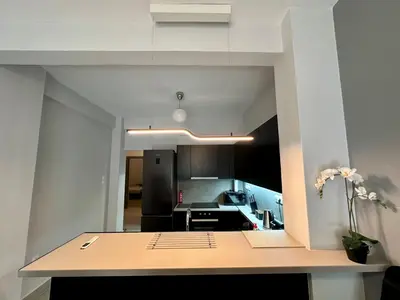 a kitchen with a table with a vase of flowers on it at Koukaki Urban Living Apartment in Athens