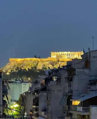 a view of a building on a hill at night at Aphrodite's Nest in Athens