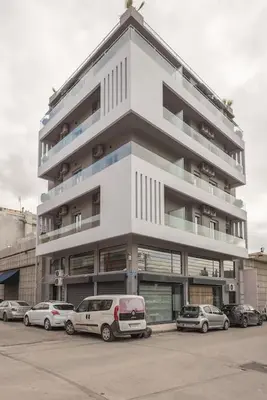 a white building with cars parked in front of it at Modern Apartment in Athens