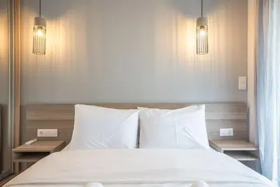 a bedroom with a bed with white sheets and pillows at Modern Apartment in Athens